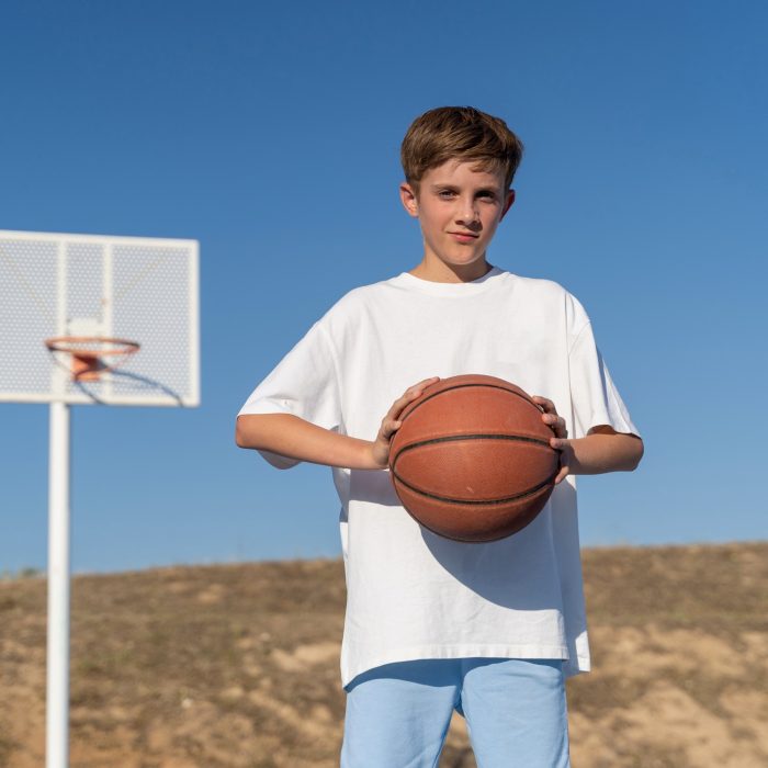 Adolescent boy with basketball on basketball court